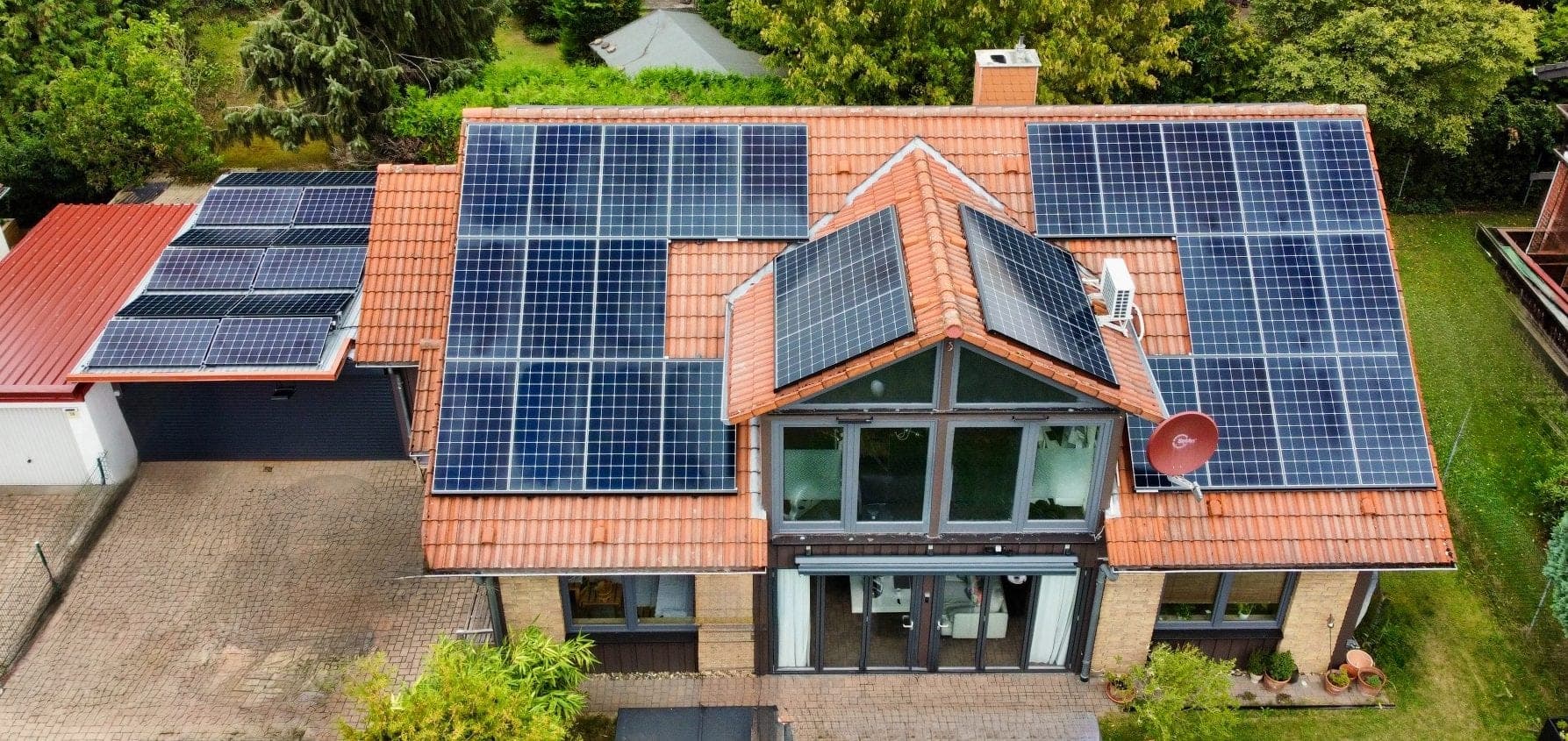 Vollflächig mit Photovoltaikmodulen belegtes Dach aus der Luft